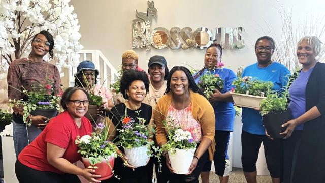 Blossoms Floral Academy students posing with potted plants.